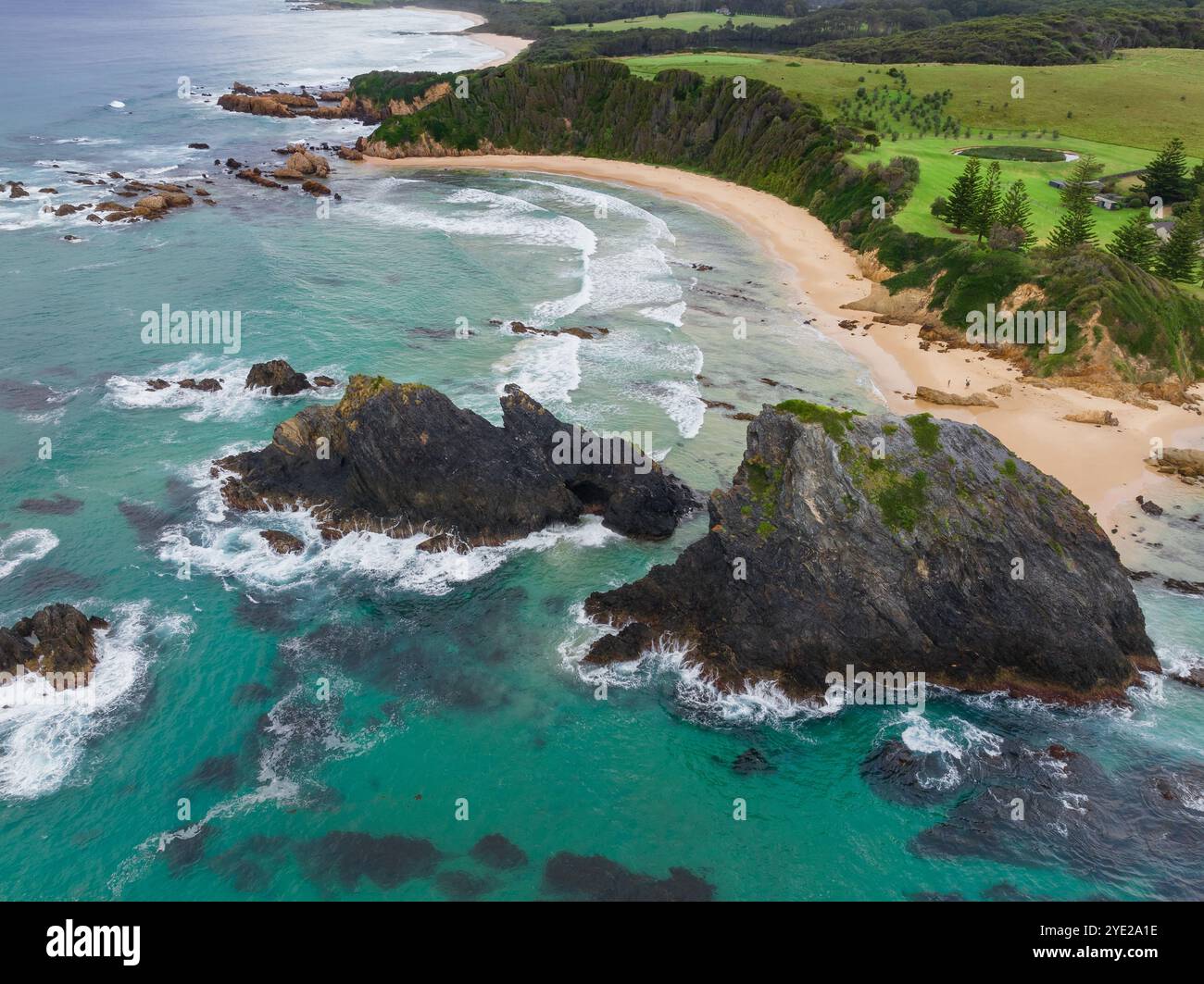 Vue aérienne d'une formation rocheuse déchiquetée au large d'une plage de sable à Naroom sur la côte sud de la Nouvelle-Galles du Sud, Australie Banque D'Images