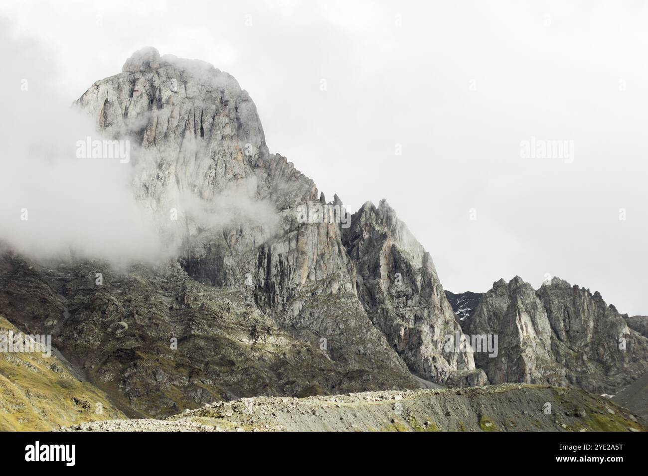 Un sommet de montagne accidenté en Géorgie pendant l'automne, avec une couche de brume couvrant partiellement ses parties supérieures, ajoutant une atmosphère mystérieuse. Le Rocky Banque D'Images