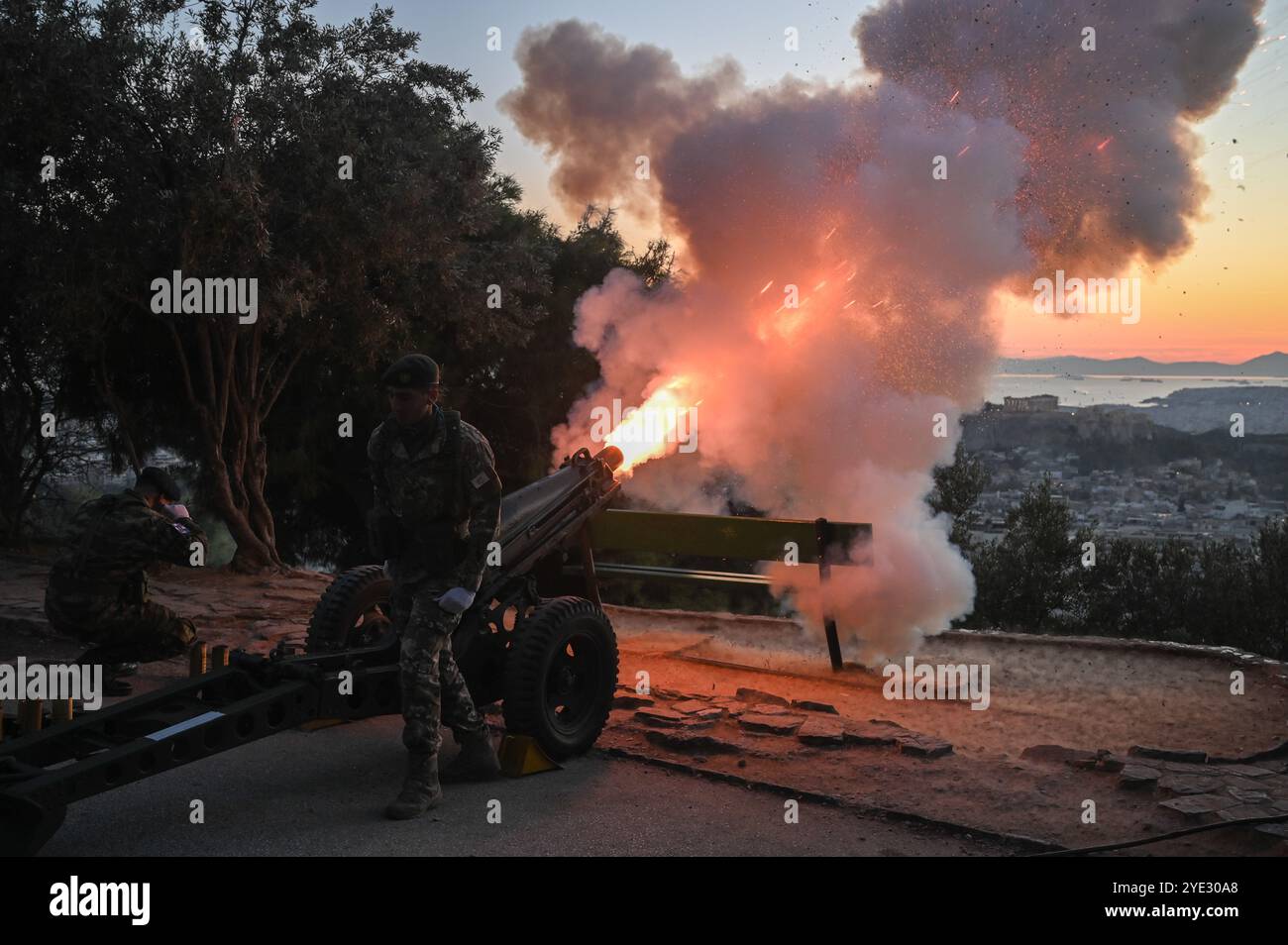 Athènes, Grèce. 28 octobre 2024. Les soldats grecs tirent un canon au-dessus de la ville d'Athènes, tandis que l'Acropole peut être vue en arrière-plan, lors des célébrations marquant la Journée de l'OHI. Le jour de l'OHI est un jour férié national qui commémore le refus de la Grèce de permettre aux troupes de l'axe d'entrer sur son territoire pendant la guerre mondiale III crédit : Dimitris Aspiotis/Alamy Banque D'Images