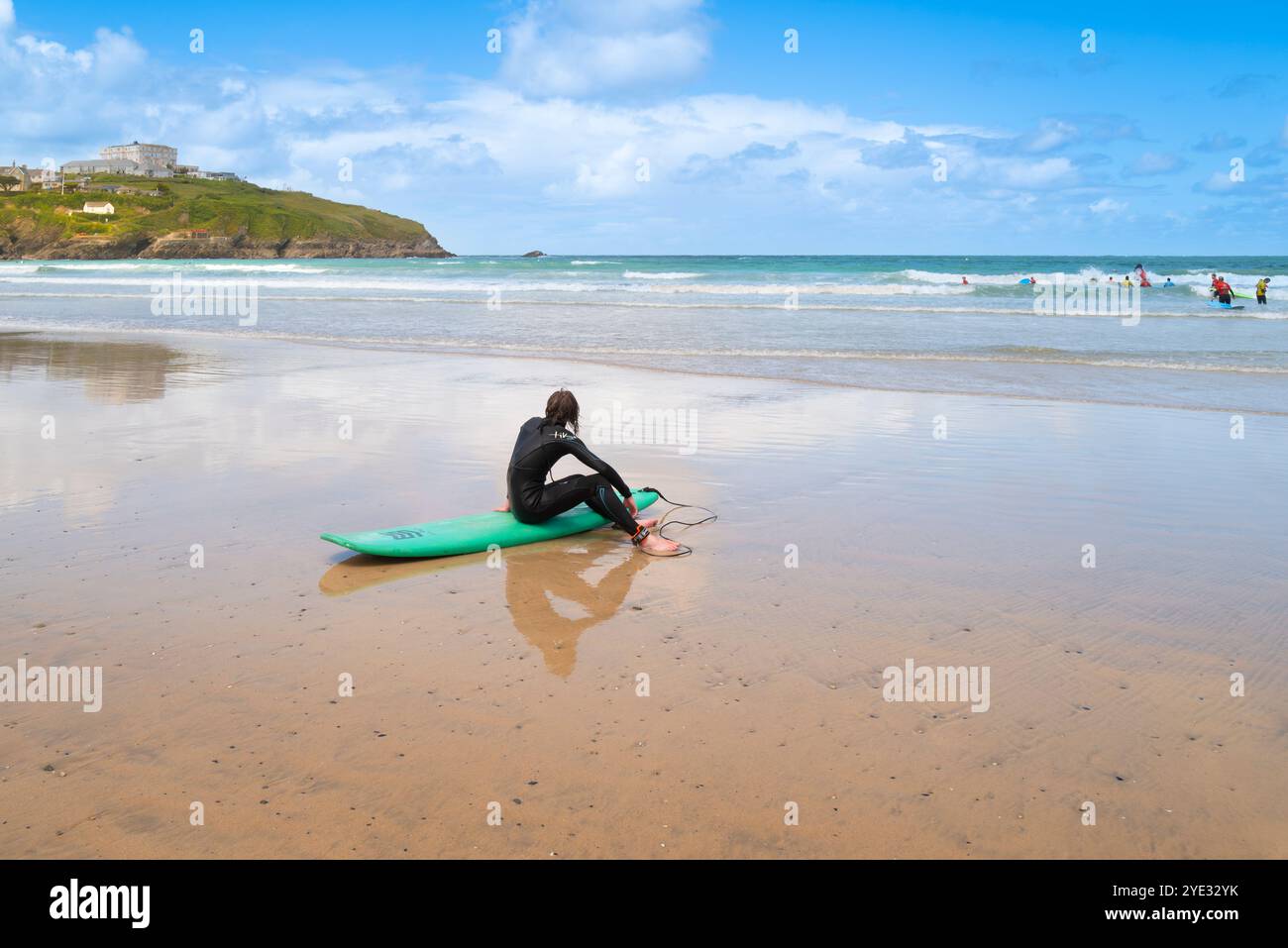 Un surfeur fatigué prenant une pause de surf assis sur sa planche de surf sur Towan Beach à Newquay en Cornouailles au Royaume-Uni. Banque D'Images Un surfeur fatigué prenant une pause de surf assis sur sa planche de surf sur Towan Beach à Newquay en Cornouailles au Royaume-Uni. Banque D'Images