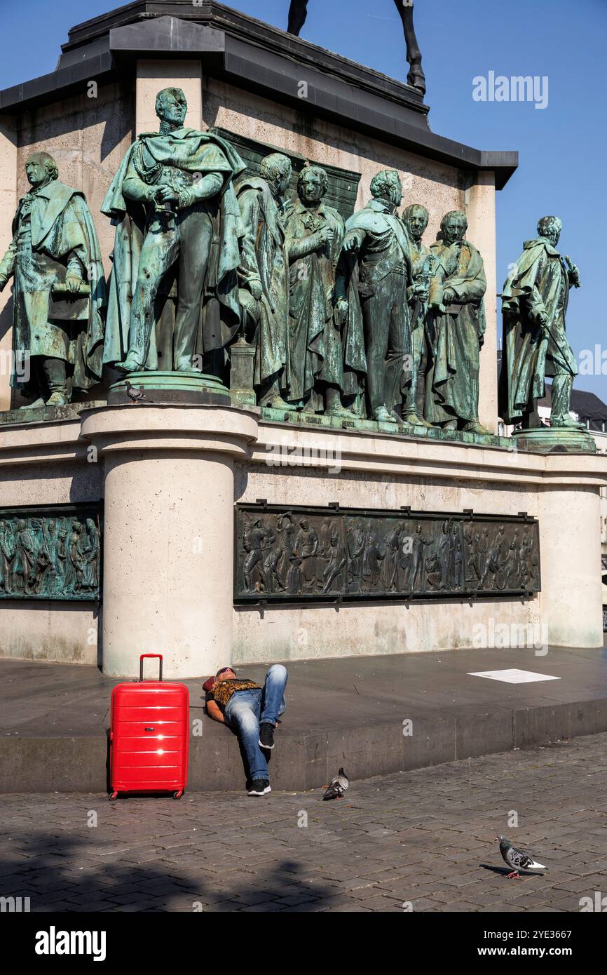 Un homme avec un chariot rouge se trouve à la statue équestre Empereur Friedrich Wilhem III, roi de Prusse au Heumarket, statues sur le piédestal, Cologn Banque D'Images