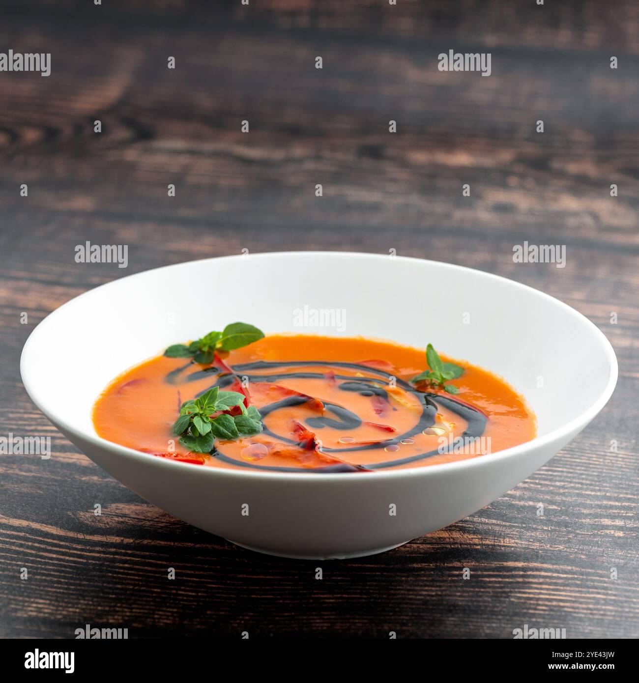 Une assiette de soupe de tomates maison avec fond de bois rustique basilic Banque D'Images