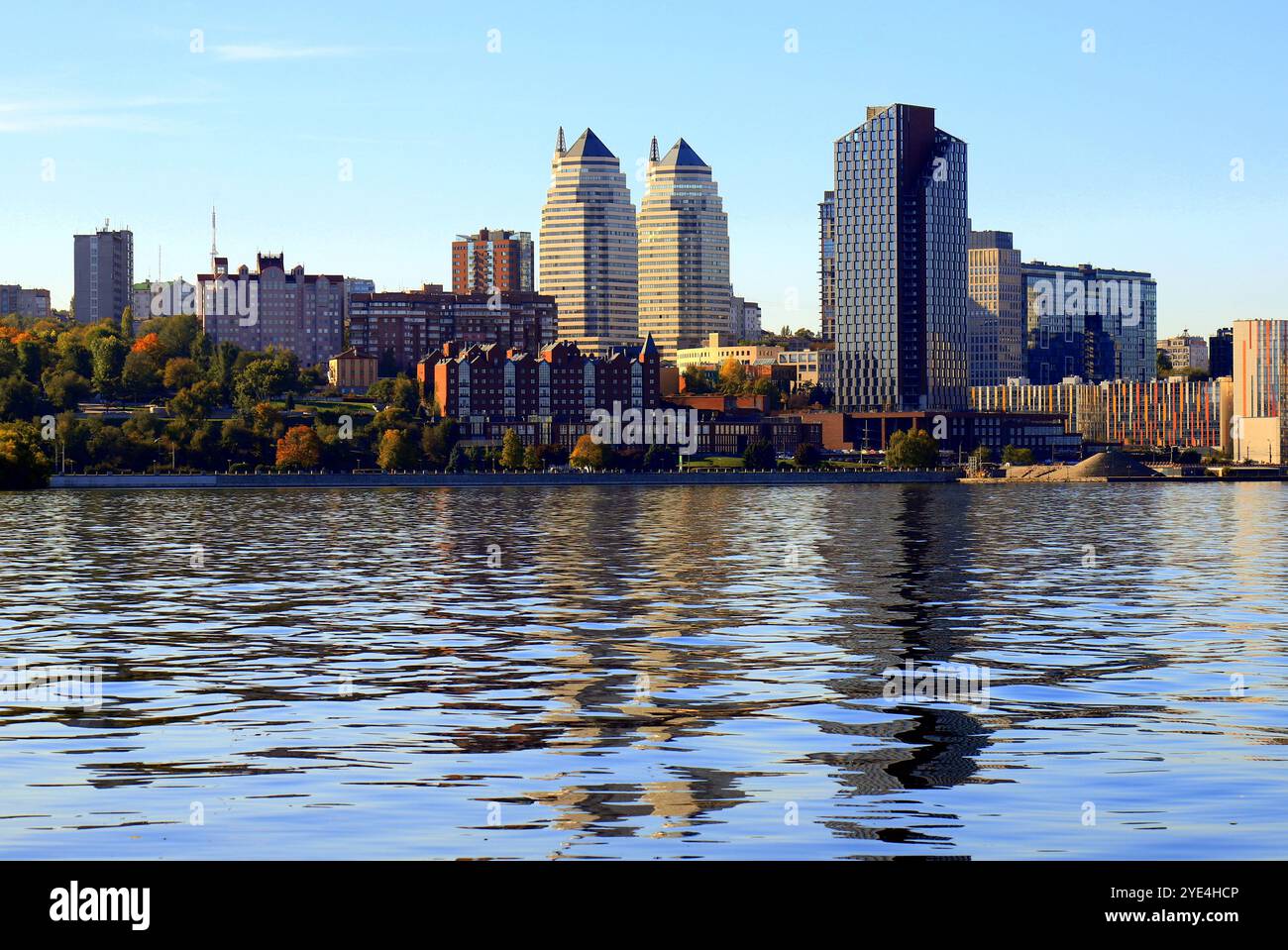 Grande ville sur Banks large rivière. Ville ukrainienne Dnipro, Ukraine. Belles tours modernes, bâtiments, gratte-ciel se reflètent dans l'eau matin, rivière flo Banque D'Images