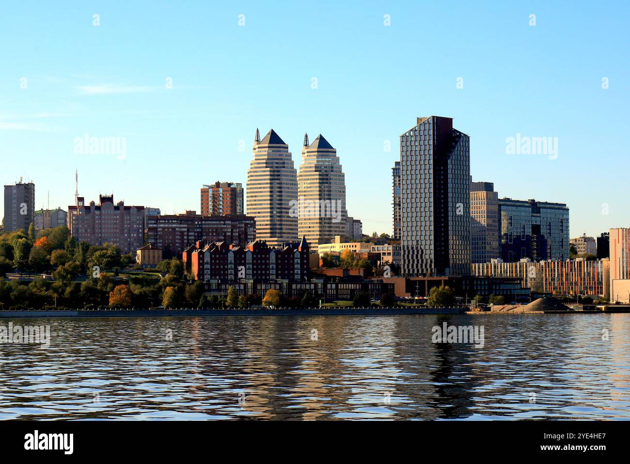 Grande ville sur Banks large rivière. Ville ukrainienne Dnipro, Ukraine. Belles tours modernes, bâtiments, gratte-ciel se reflètent dans l'eau matin, rivière flo Banque D'Images