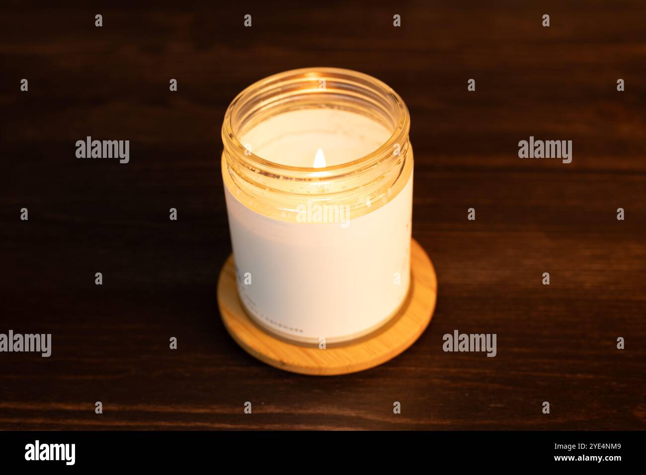 bougie parfumée allumée faite avec de la cire de soja sur une table en bois foncé. Banque D'Images