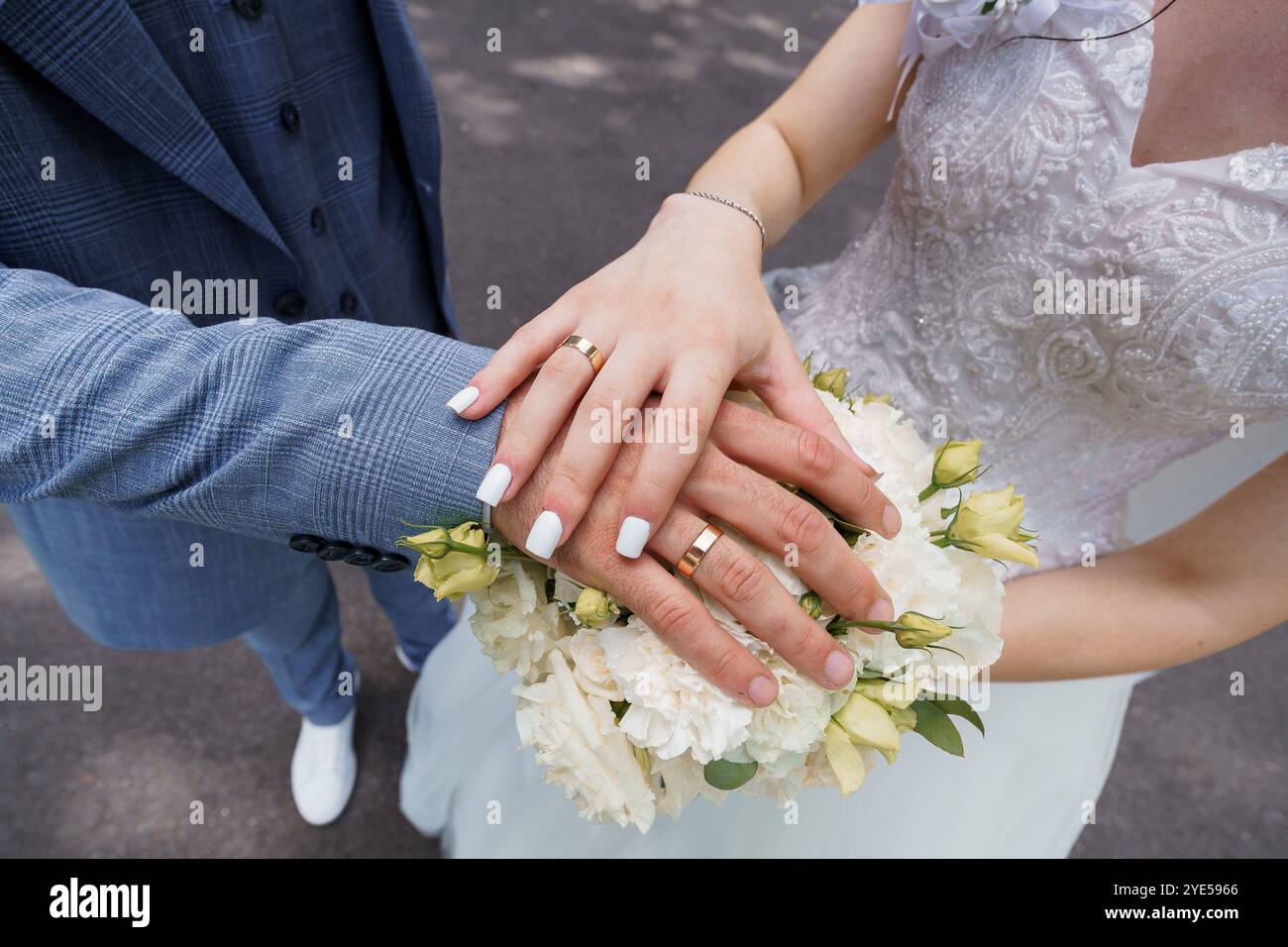 Un moment de mariage romantique avec des mains entrelacées et bouquet floral. Banque D'Images