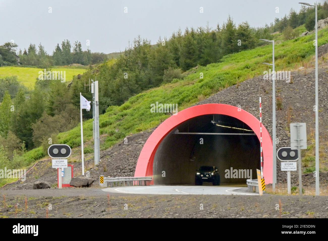 Akureyri, Islande - 24 août 2024 : voiture quittant l'entrée de l'un des longs tunnels routiers qui relient les villes de la région reculée du nord de l'Islande Banque D'Images