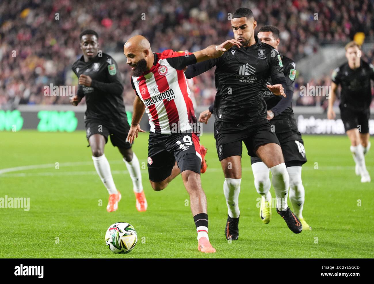 Bryan Mbeumo de Brentford (au centre gauche) et Max Lowe de Sheffield Wednesday (au centre droite) se battent pour le ballon lors du match de quatrième tour de la Coupe Carabao au Gtech Community Stadium de Londres. Date de la photo : mardi 29 octobre 2024. Banque D'Images