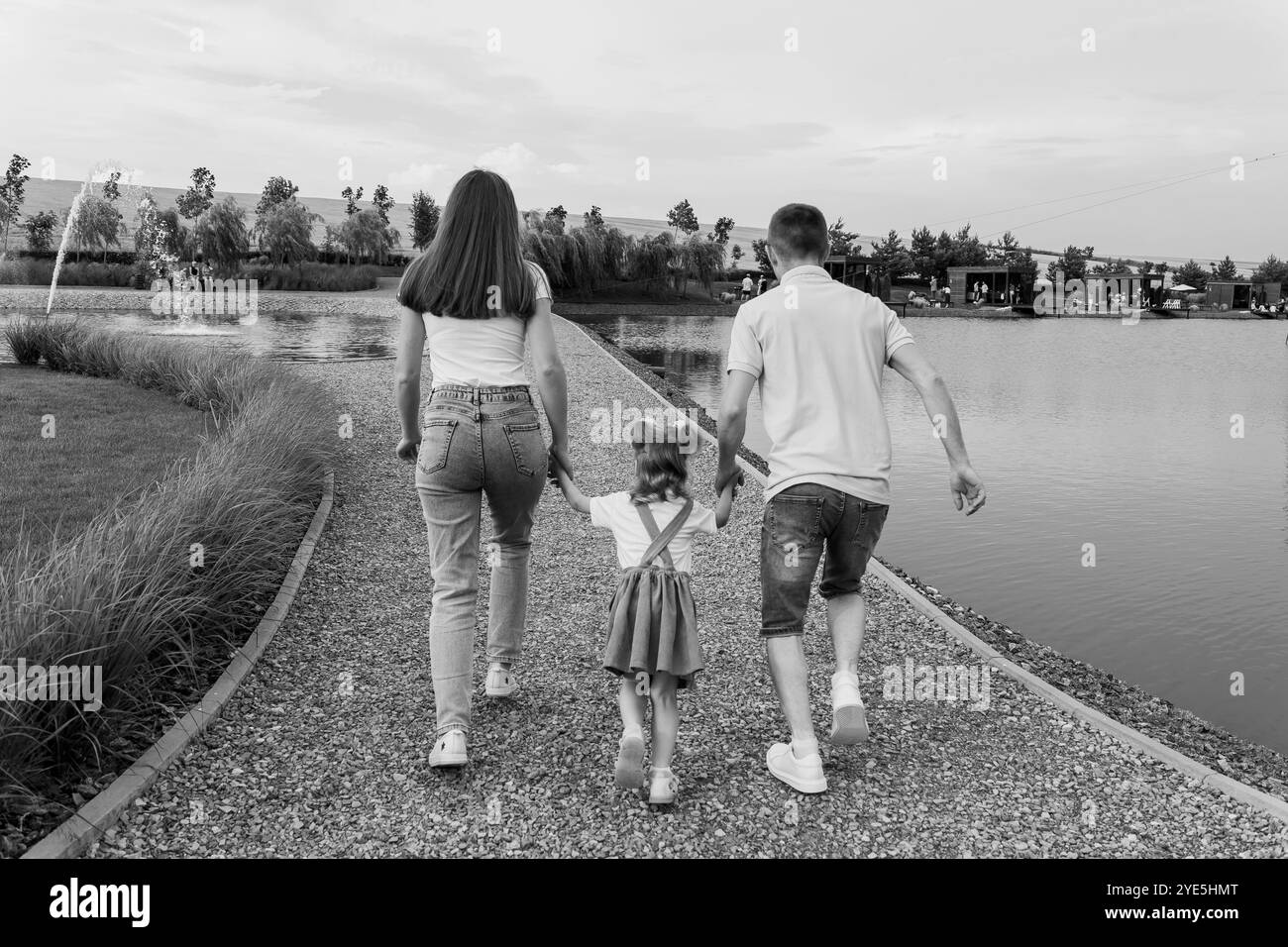 Promenade en famille au bord du lac tranquille au coucher du soleil. Banque D'Images