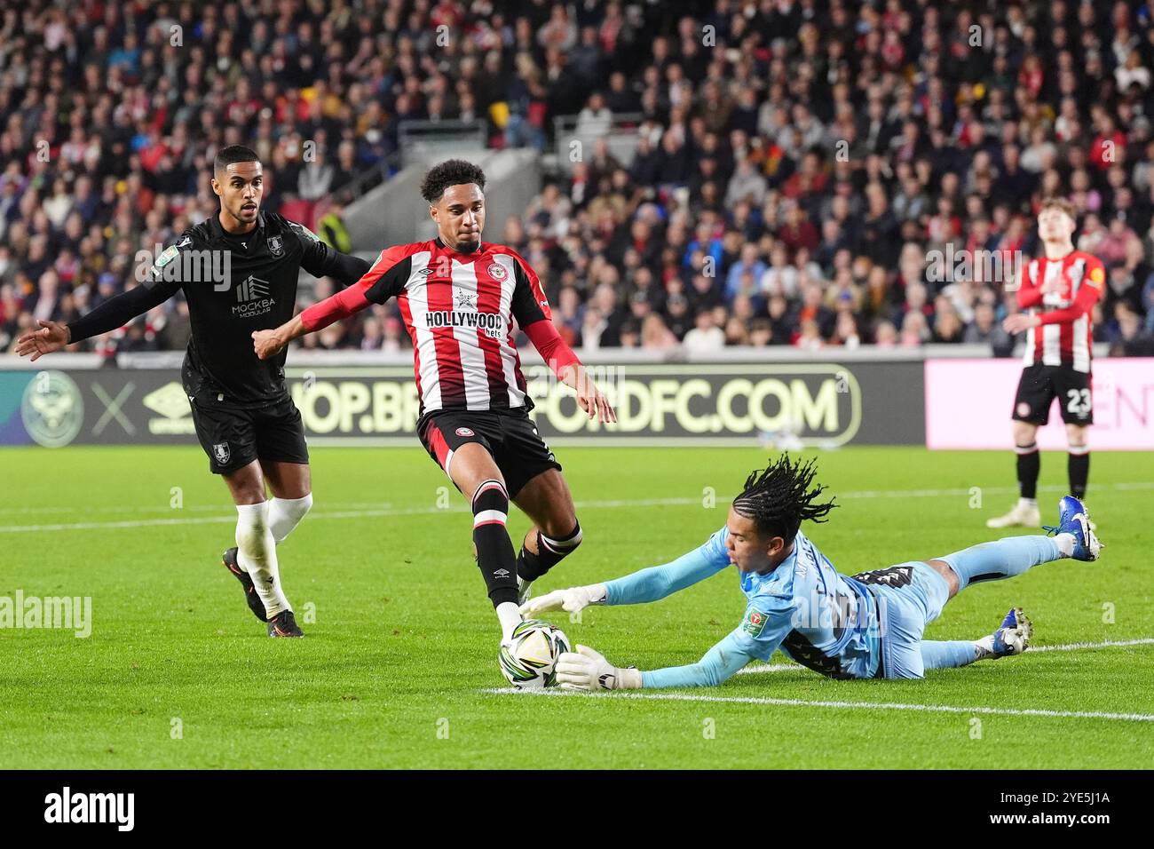 Le gardien Pierce Charles de Sheffield mercredi sauve aux pieds de Kevin Schade de Brentford (au centre) lors du match de quatrième tour de la Carabao Cup au Gtech Community Stadium de Londres. Date de la photo : mardi 29 octobre 2024. Banque D'Images