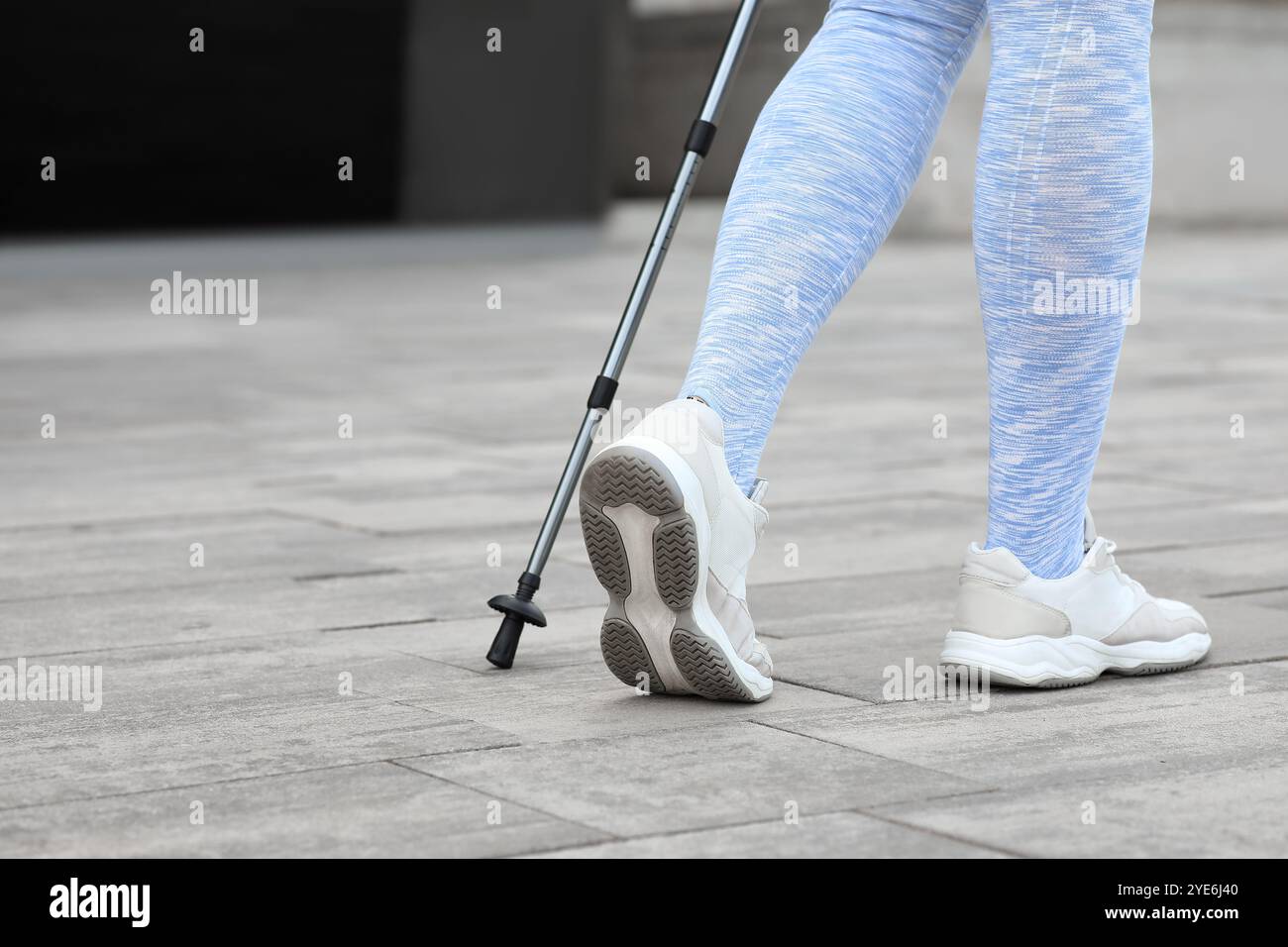 Femme sportive faisant de la marche nordique dans la rue, vue arrière Banque D'Images