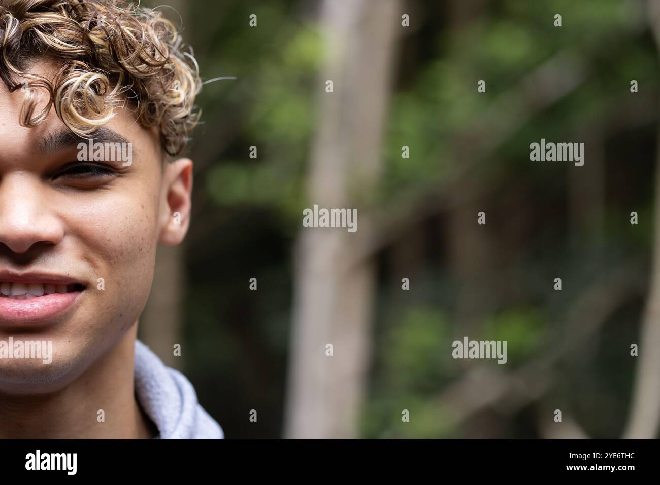 Jeune homme souriant appréciant la promenade dans la nature dans la forêt, se sentant détendu et heureux, copiez l'espace Banque D'Images