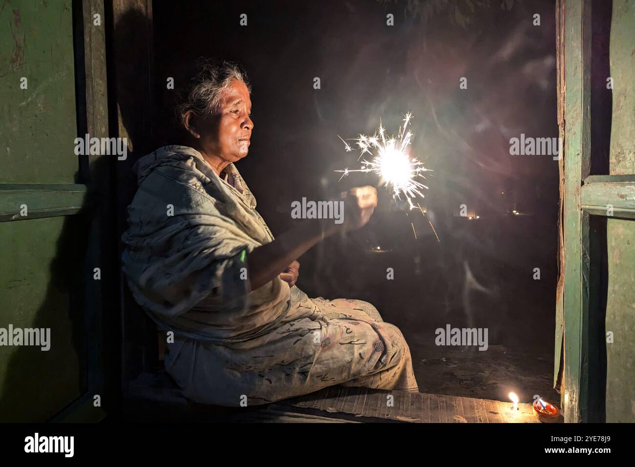 FENI, BANGLADESH - 17 OCTOBRE : une vieille femme hindoue jouant avec la lumière pendant le 'Deep Utsav ou festival de lumière' avant le festival Diwali à Feni, Bang Banque D'Images