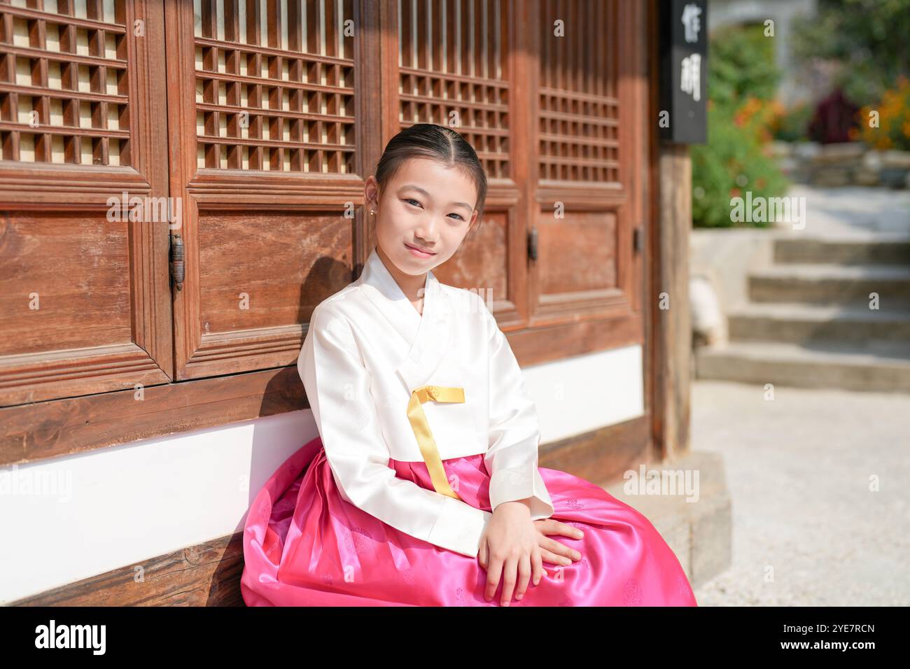 Une jeune coréenne de 9 ans portant un hanbok se tient debout devant un bâtiment traditionnel dans la ville historique de Gyedong-gil, district de Jongno, Séoul. Banque D'Images