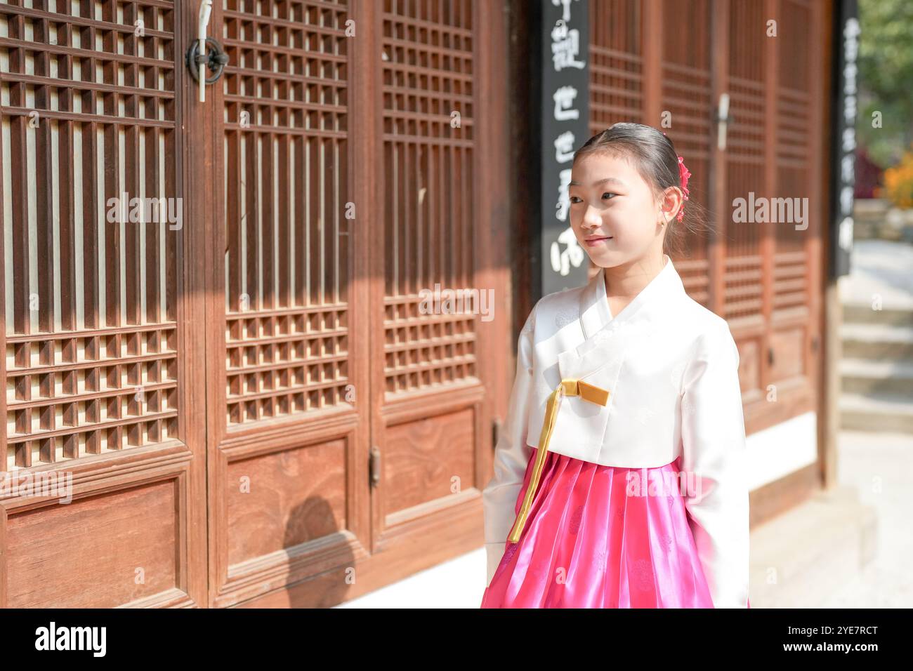 Une jeune coréenne de 9 ans portant un hanbok se tient debout devant un bâtiment traditionnel dans la ville historique de Gyedong-gil, district de Jongno, Séoul. Banque D'Images