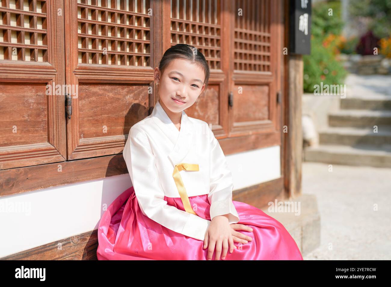Une jeune coréenne de 9 ans portant un hanbok se tient debout devant un bâtiment traditionnel dans la ville historique de Gyedong-gil, district de Jongno, Séoul. Banque D'Images