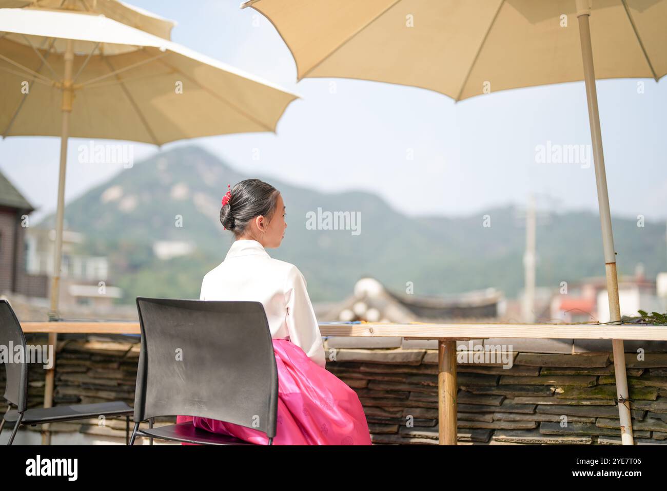 Une jeune coréenne de 9 ans portant un hanbok regarde un bâtiment traditionnel dans la ville historique de Gyedong-gil, district de Jongno, Séoul, Corée. Banque D'Images