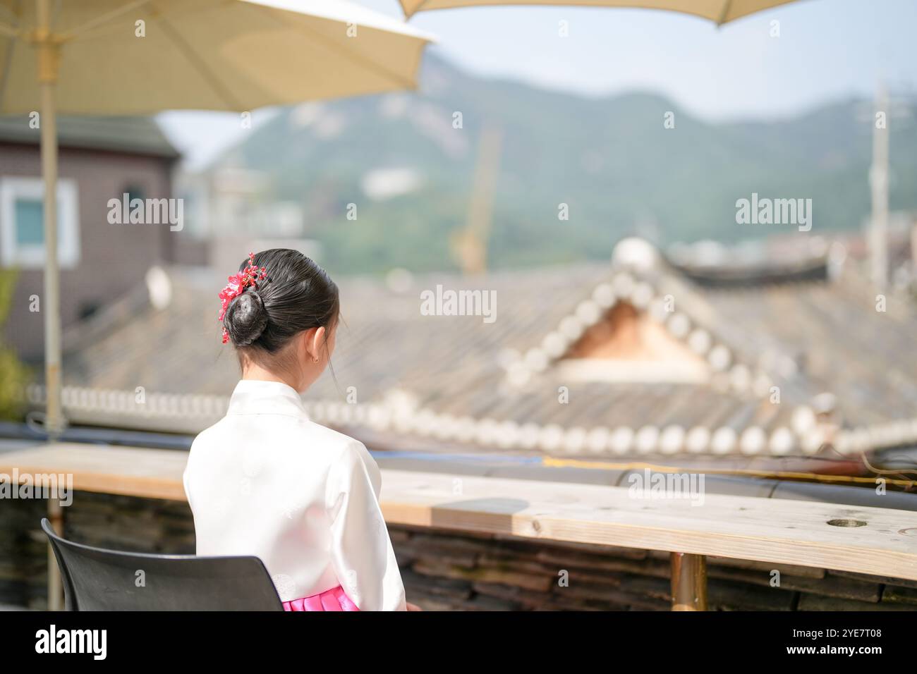 Une jeune coréenne de 9 ans portant un hanbok regarde un bâtiment traditionnel dans la ville historique de Gyedong-gil, district de Jongno, Séoul, Corée. Banque D'Images