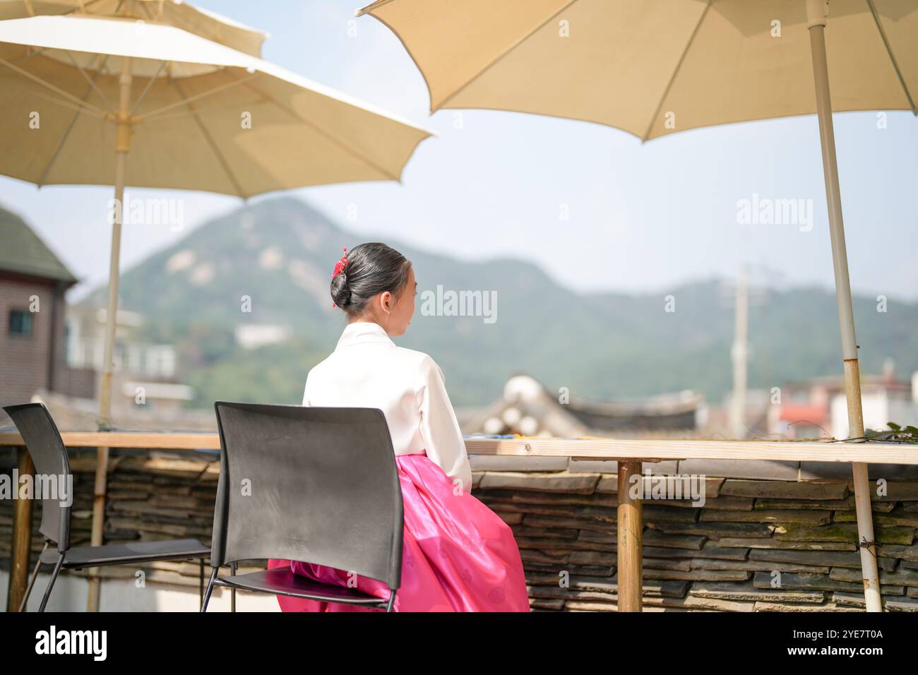 Une jeune coréenne de 9 ans portant un hanbok regarde un bâtiment traditionnel dans la ville historique de Gyedong-gil, district de Jongno, Séoul, Corée. Banque D'Images