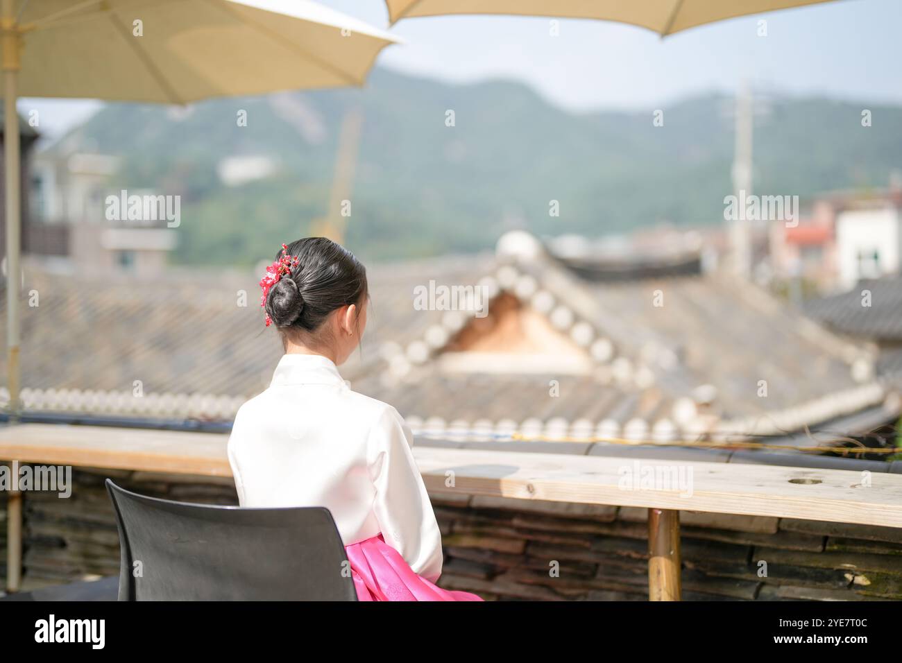 Une jeune coréenne de 9 ans portant un hanbok regarde un bâtiment traditionnel dans la ville historique de Gyedong-gil, district de Jongno, Séoul, Corée. Banque D'Images