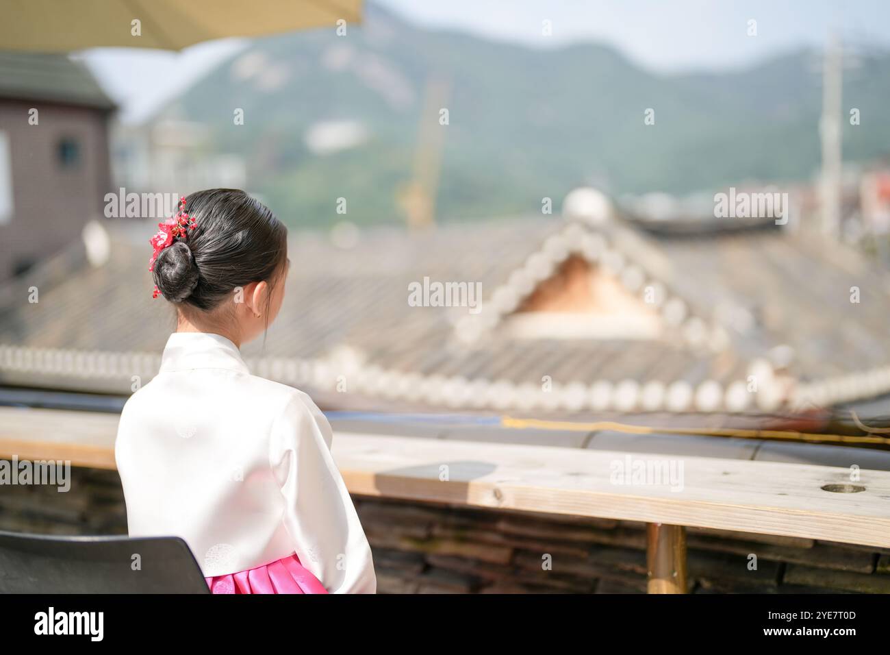 Une jeune coréenne de 9 ans portant un hanbok regarde un bâtiment traditionnel dans la ville historique de Gyedong-gil, district de Jongno, Séoul, Corée. Banque D'Images