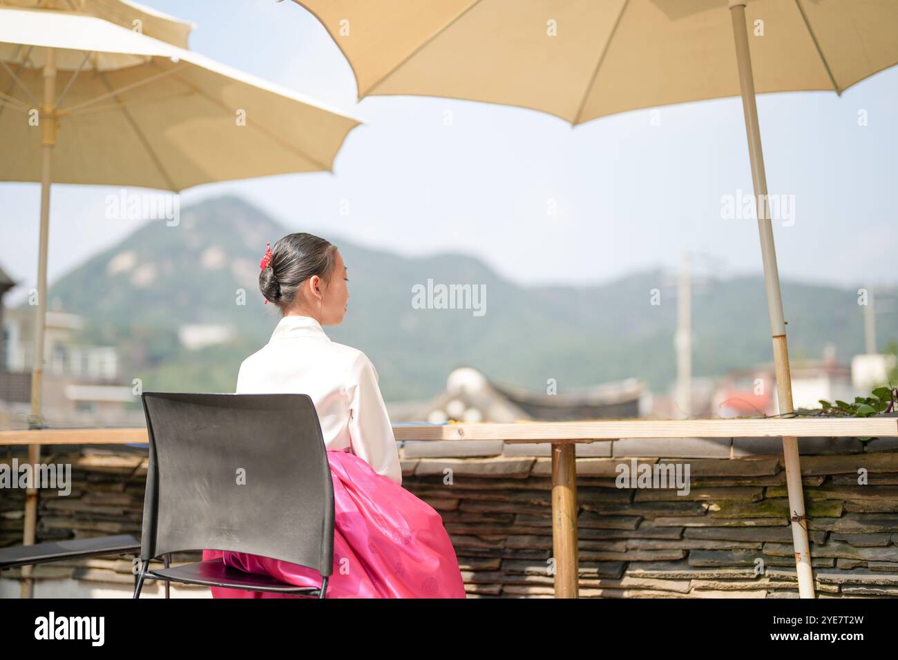 Une jeune coréenne de 9 ans portant un hanbok regarde un bâtiment traditionnel dans la ville historique de Gyedong-gil, district de Jongno, Séoul, Corée. Banque D'Images