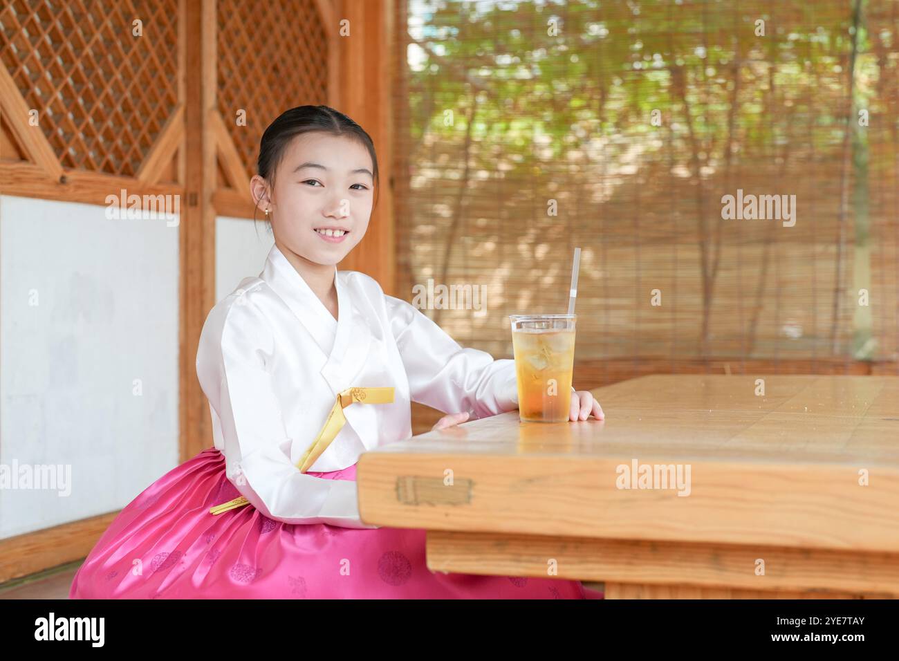 Une jeune coréenne de 9 ans portant un hanbok boit une boisson dans un bâtiment traditionnel de la ville historique de Gyedong-gil, dans le district de Jongno, au sud Banque D'Images