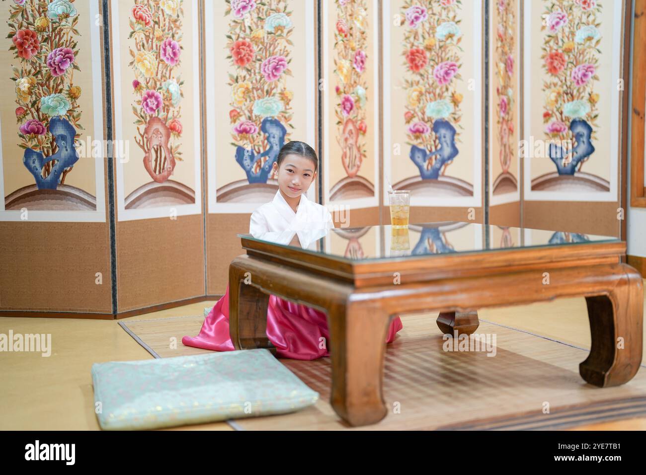 Une jeune coréenne de 9 ans portant un hanbok boit une boisson dans un bâtiment traditionnel de la ville historique de Gyedong-gil, dans le district de Jongno, au sud Banque D'Images
