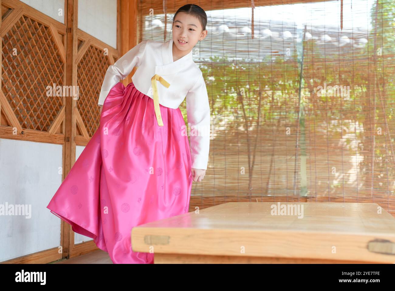 Une jeune coréenne de 9 ans portant un hanbok boit une boisson dans un bâtiment traditionnel de la ville historique de Gyedong-gil, dans le district de Jongno, au sud Banque D'Images