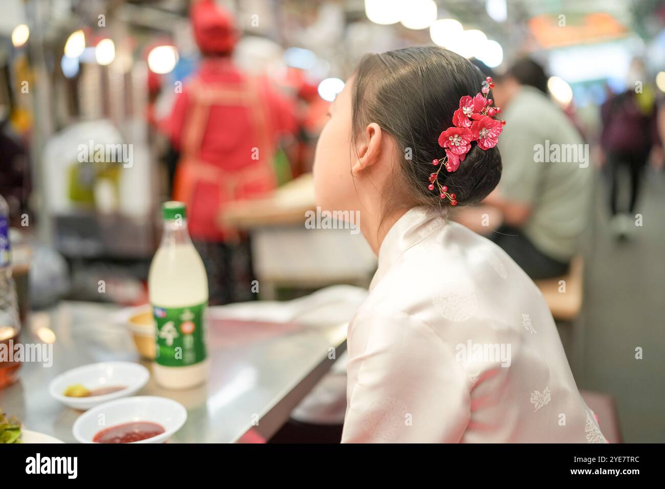 Une jeune coréenne de 9 ans portant un hanbok mange un repas dans un marché local de Changgyeonggung-ro, district de Jongno, Séoul, Corée. Banque D'Images