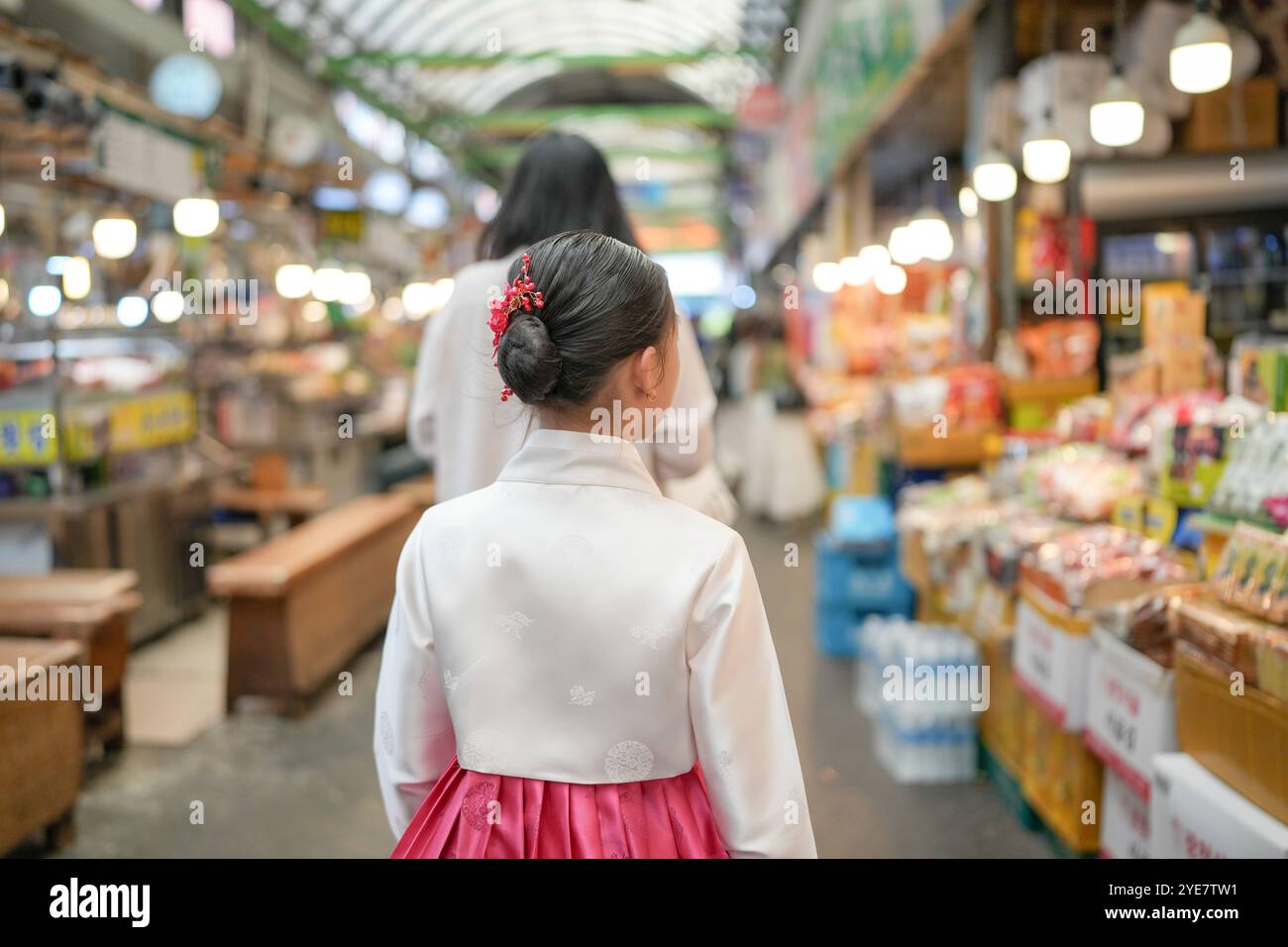 Une jeune coréenne de 9 ans portant un hanbok mange un repas dans un marché local de Changgyeonggung-ro, district de Jongno, Séoul, Corée. Banque D'Images