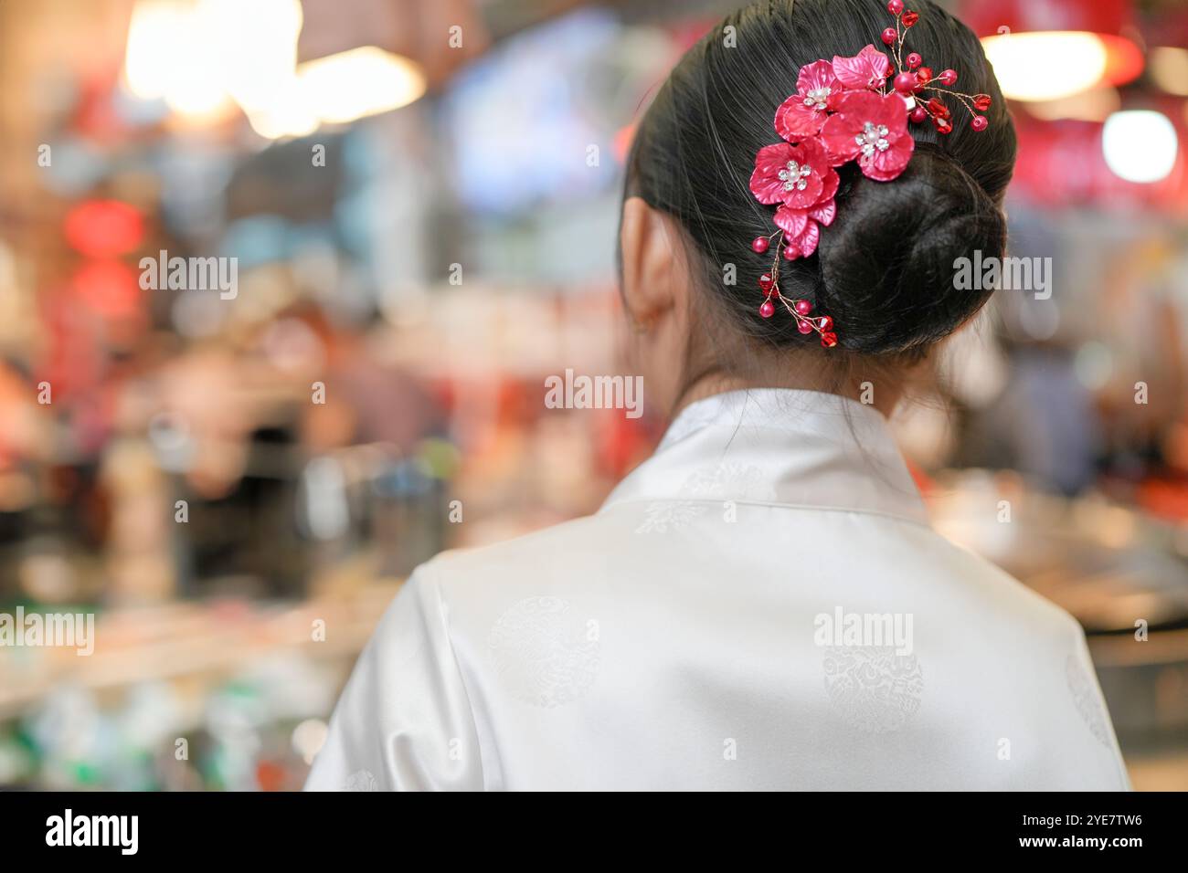 Une jeune coréenne de 9 ans portant un hanbok mange un repas dans un marché local de Changgyeonggung-ro, district de Jongno, Séoul, Corée. Banque D'Images