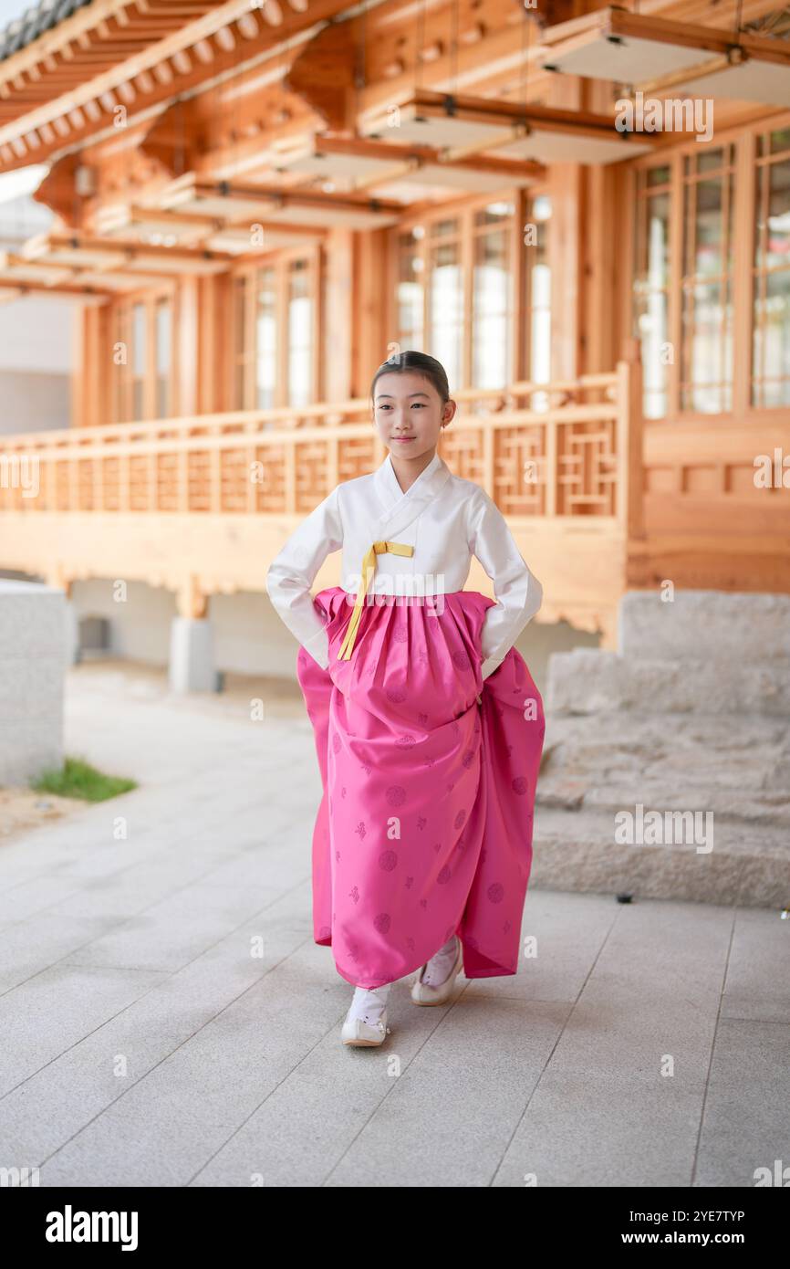 Une jeune coréenne de 9 ans portant un hanbok exécute une danse traditionnelle devant un bâtiment traditionnel dans la ville historique de Gyedong-gil, JO Banque D'Images