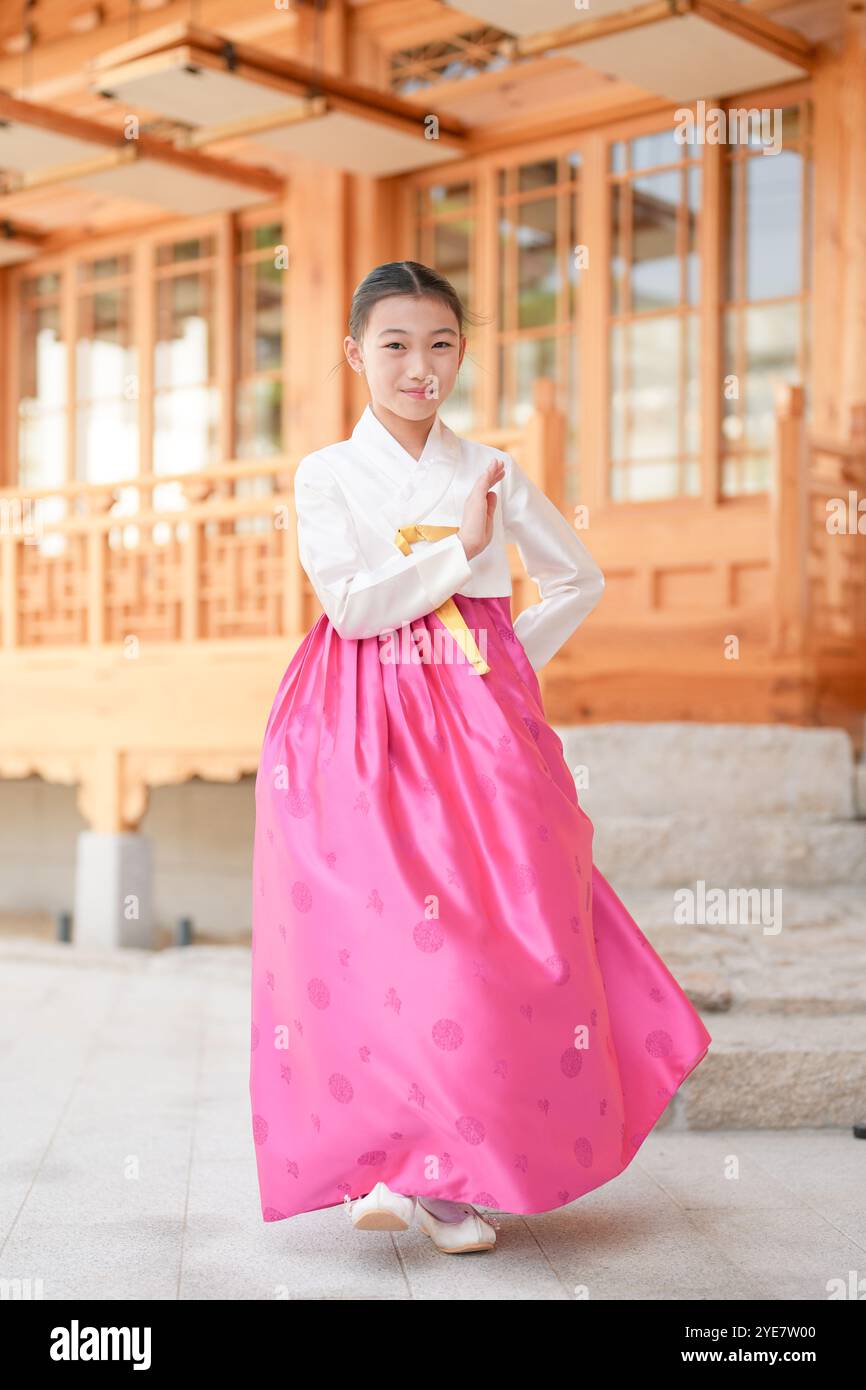 Une jeune coréenne de 9 ans portant un hanbok exécute une danse traditionnelle devant un bâtiment traditionnel dans la ville historique de Gyedong-gil, JO Banque D'Images