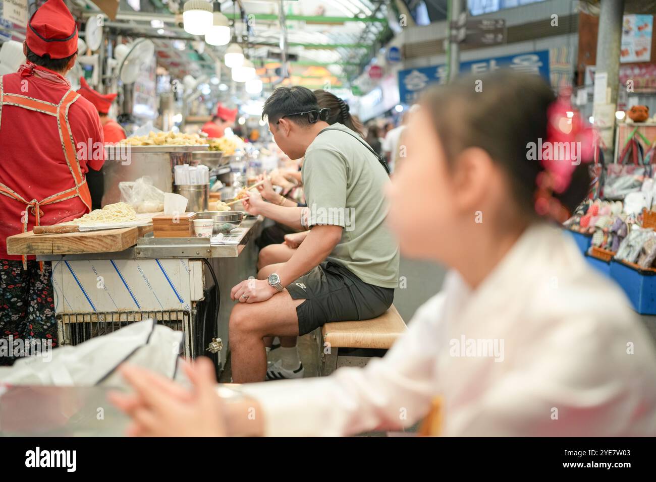 Une jeune coréenne de 9 ans portant un hanbok mange un repas dans un marché local de Changgyeonggung-ro, district de Jongno, Séoul, Corée. Banque D'Images