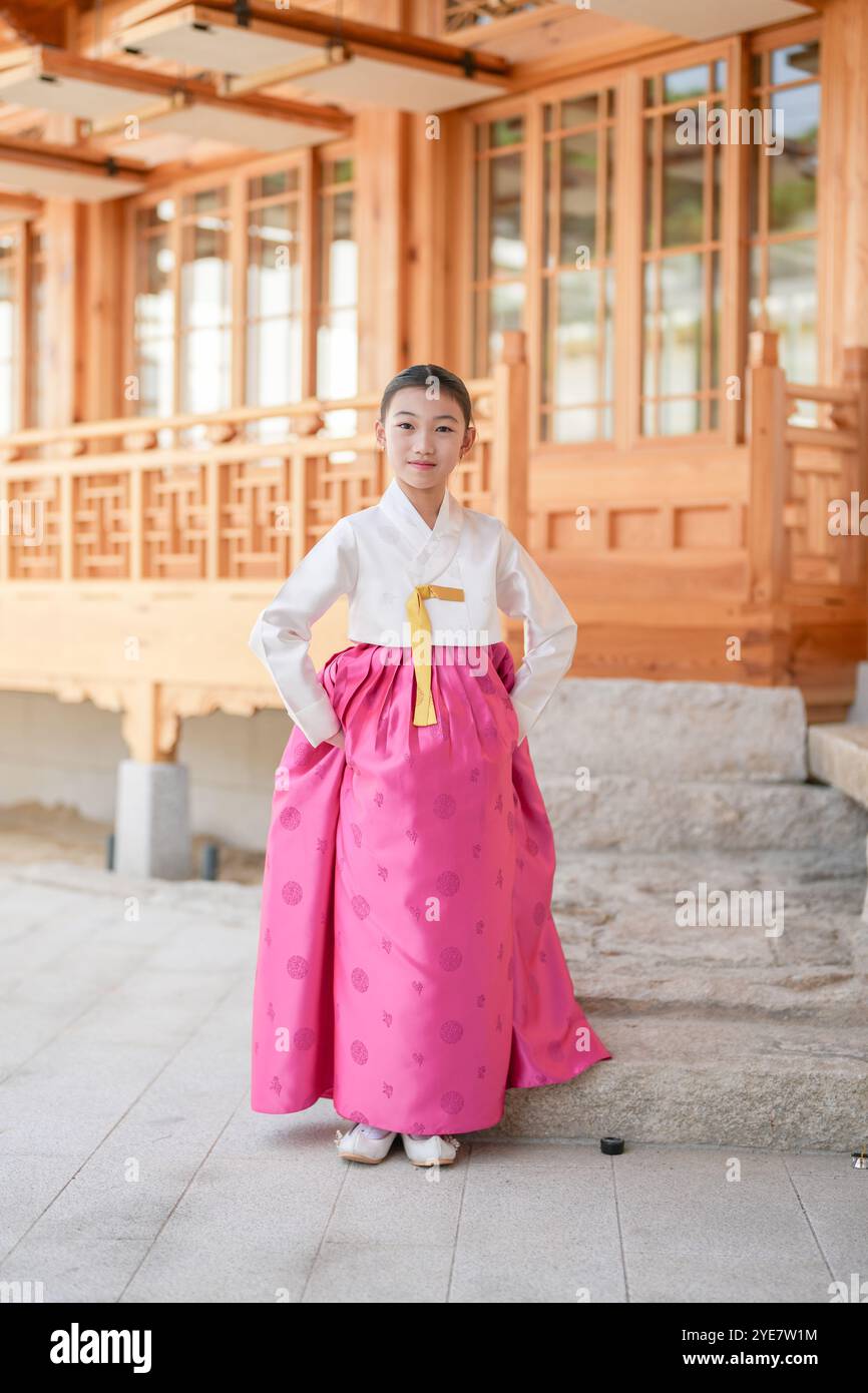 Une jeune coréenne de 9 ans portant un hanbok exécute une danse traditionnelle devant un bâtiment traditionnel dans la ville historique de Gyedong-gil, JO Banque D'Images