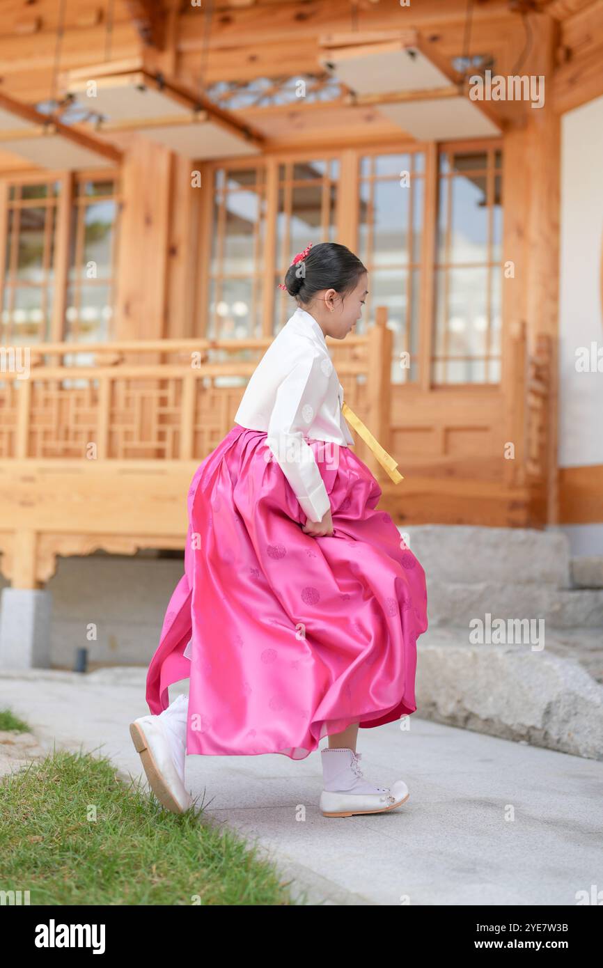 Une jeune coréenne de 9 ans portant un hanbok exécute une danse traditionnelle devant un bâtiment traditionnel dans la ville historique de Gyedong-gil, JO Banque D'Images