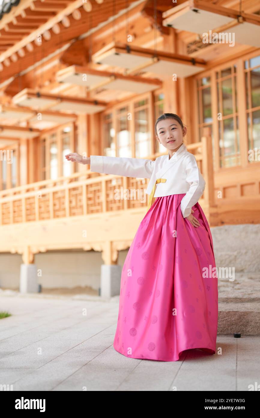 Une jeune coréenne de 9 ans portant un hanbok exécute une danse traditionnelle devant un bâtiment traditionnel dans la ville historique de Gyedong-gil, JO Banque D'Images