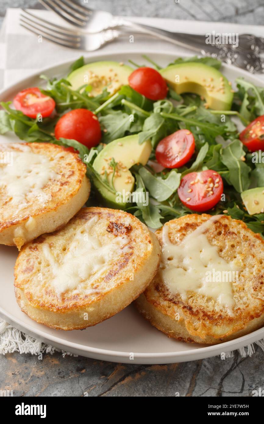 Petit déjeuner Eggy crumpets avec salade de légumes gros plan sur l'assiette sur la table. Vertical Banque D'Images