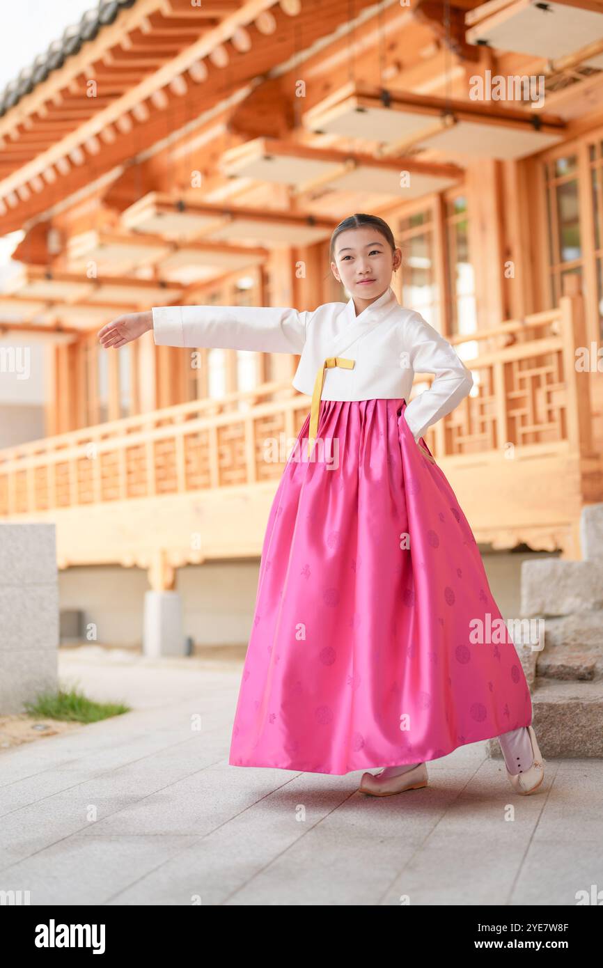 Une jeune coréenne de 9 ans portant un hanbok exécute une danse traditionnelle devant un bâtiment traditionnel dans la ville historique de Gyedong-gil, JO Banque D'Images