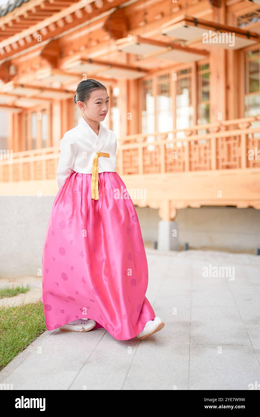Une jeune coréenne de 9 ans portant un hanbok exécute une danse traditionnelle devant un bâtiment traditionnel dans la ville historique de Gyedong-gil, JO Banque D'Images