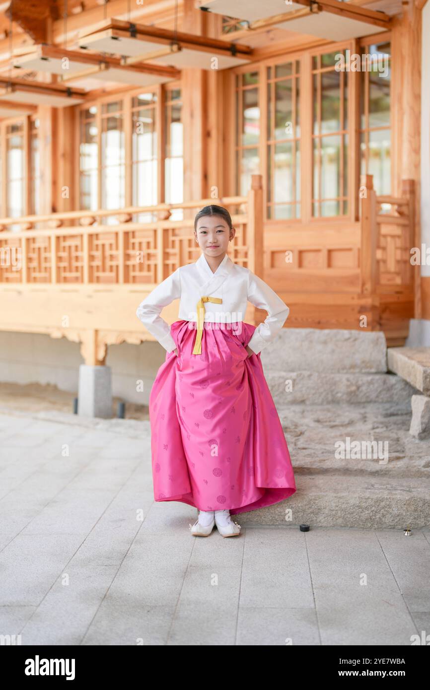 Une jeune coréenne de 9 ans portant un hanbok exécute une danse traditionnelle devant un bâtiment traditionnel dans la ville historique de Gyedong-gil, JO Banque D'Images