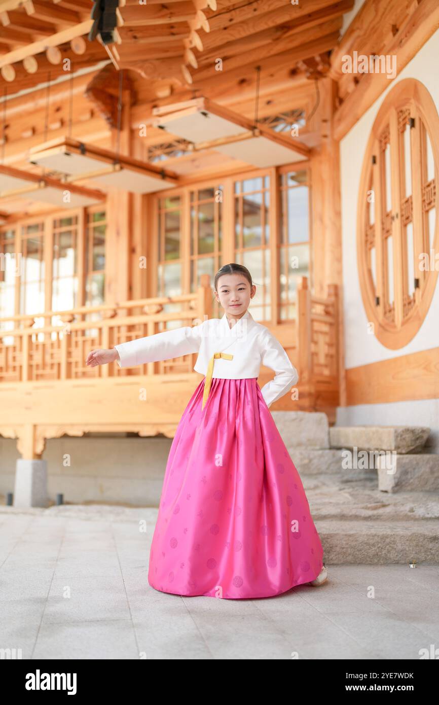 Une jeune coréenne de 9 ans portant un hanbok exécute une danse traditionnelle devant un bâtiment traditionnel dans la ville historique de Gyedong-gil, JO Banque D'Images
