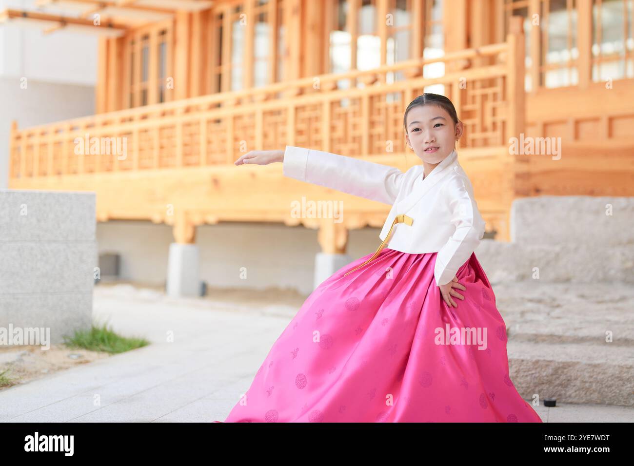 Une jeune coréenne de 9 ans portant un hanbok exécute une danse traditionnelle devant un bâtiment traditionnel dans la ville historique de Gyedong-gil, JO Banque D'Images