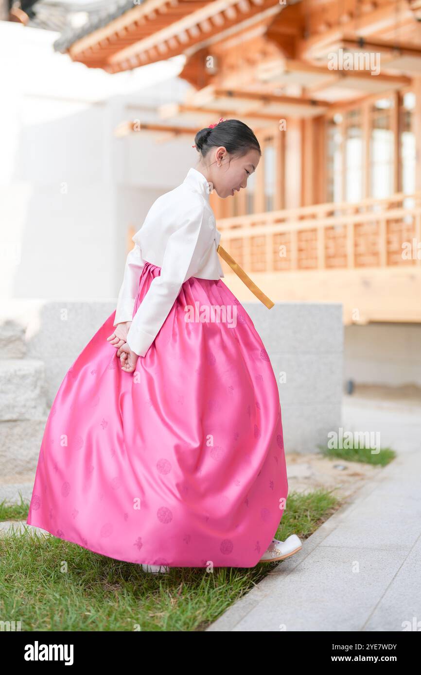 Une jeune coréenne de 9 ans portant un hanbok exécute une danse traditionnelle devant un bâtiment traditionnel dans la ville historique de Gyedong-gil, JO Banque D'Images