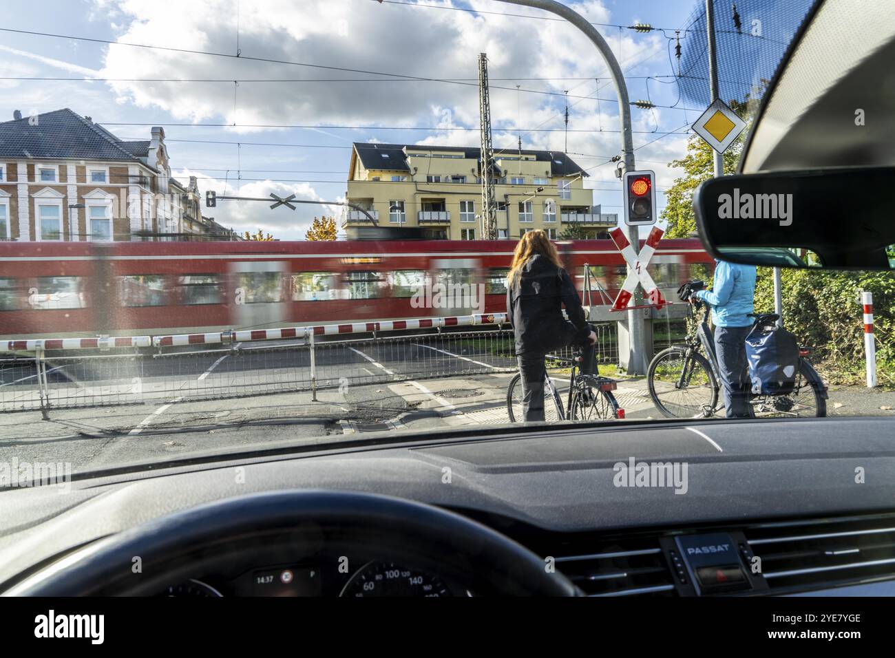 Passage à niveau interdit, barrière fermée, croix de St Andrew, feux de circulation, passage du train S-Bahn, cyclistes et automobilistes en attente, Drachenfelsstrasse cro Banque D'Images