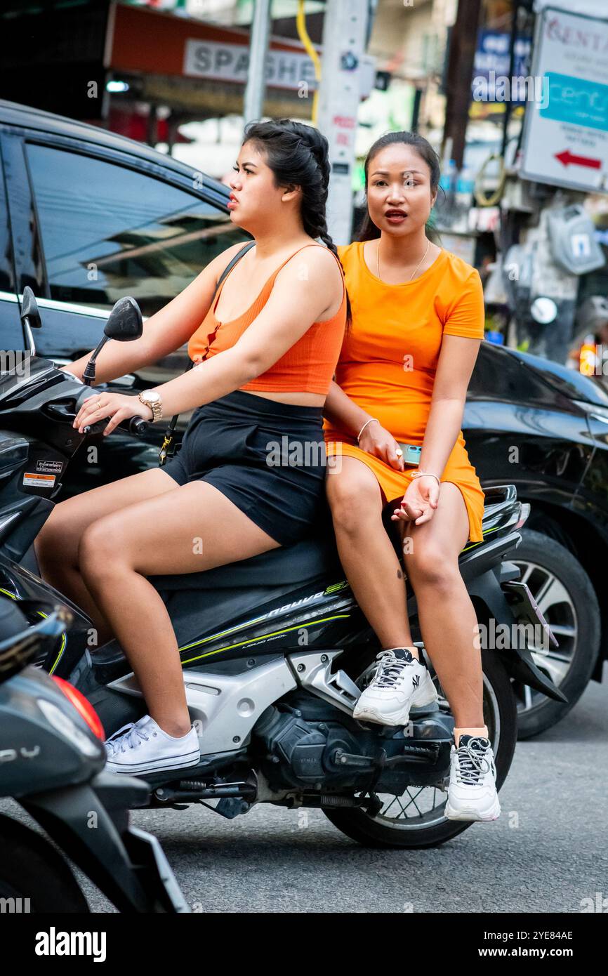 Deux filles thaïlandaises font leur chemin le long de soi Buakhao, Pattaya, Thaïlande sur leur scooter. Banque D'Images