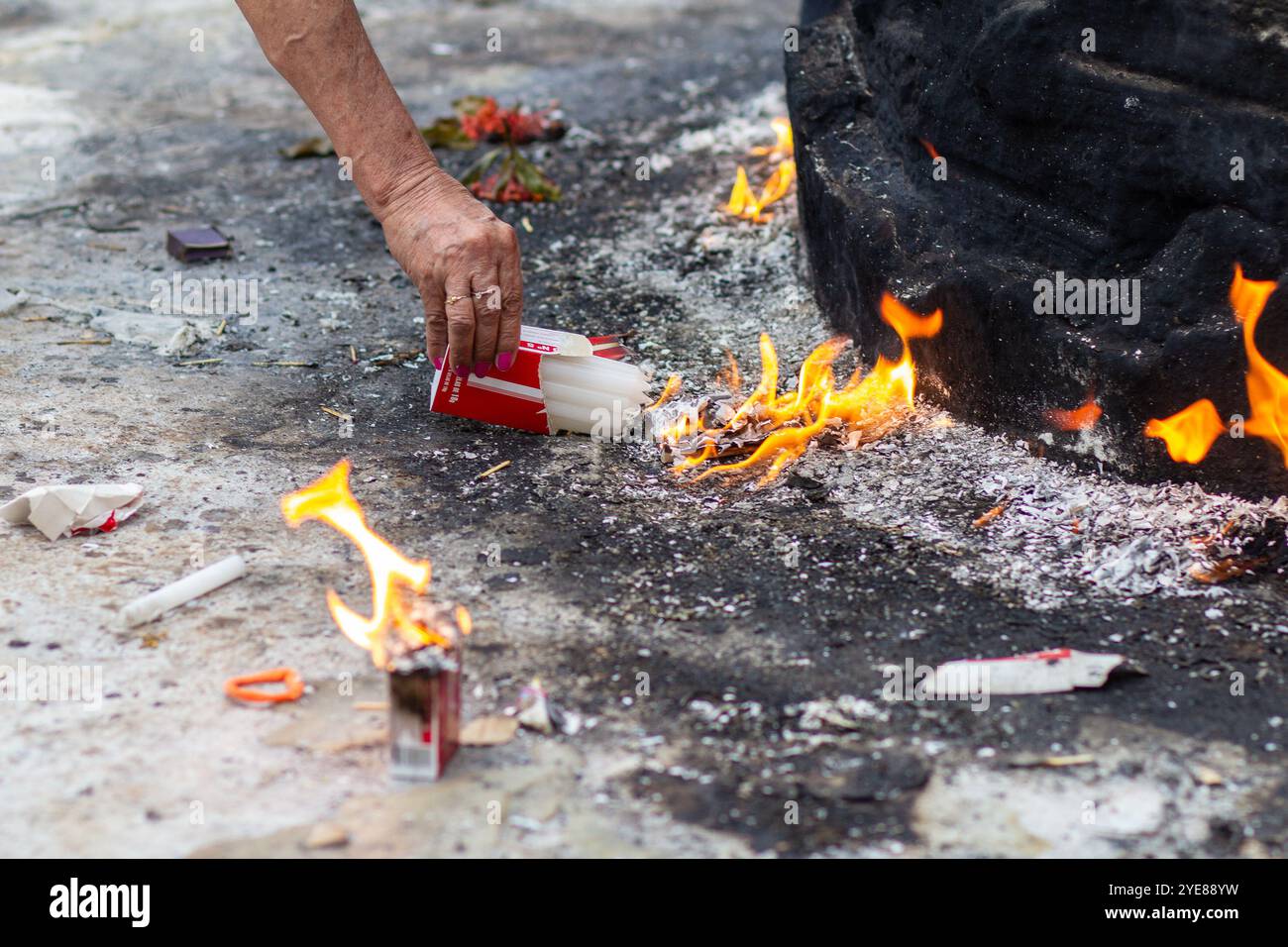 Goiania, Goias, Brésil – 02 novembre 2023 : détail du bras d'une personne allumant une bougie dans un cimetière. Banque D'Images