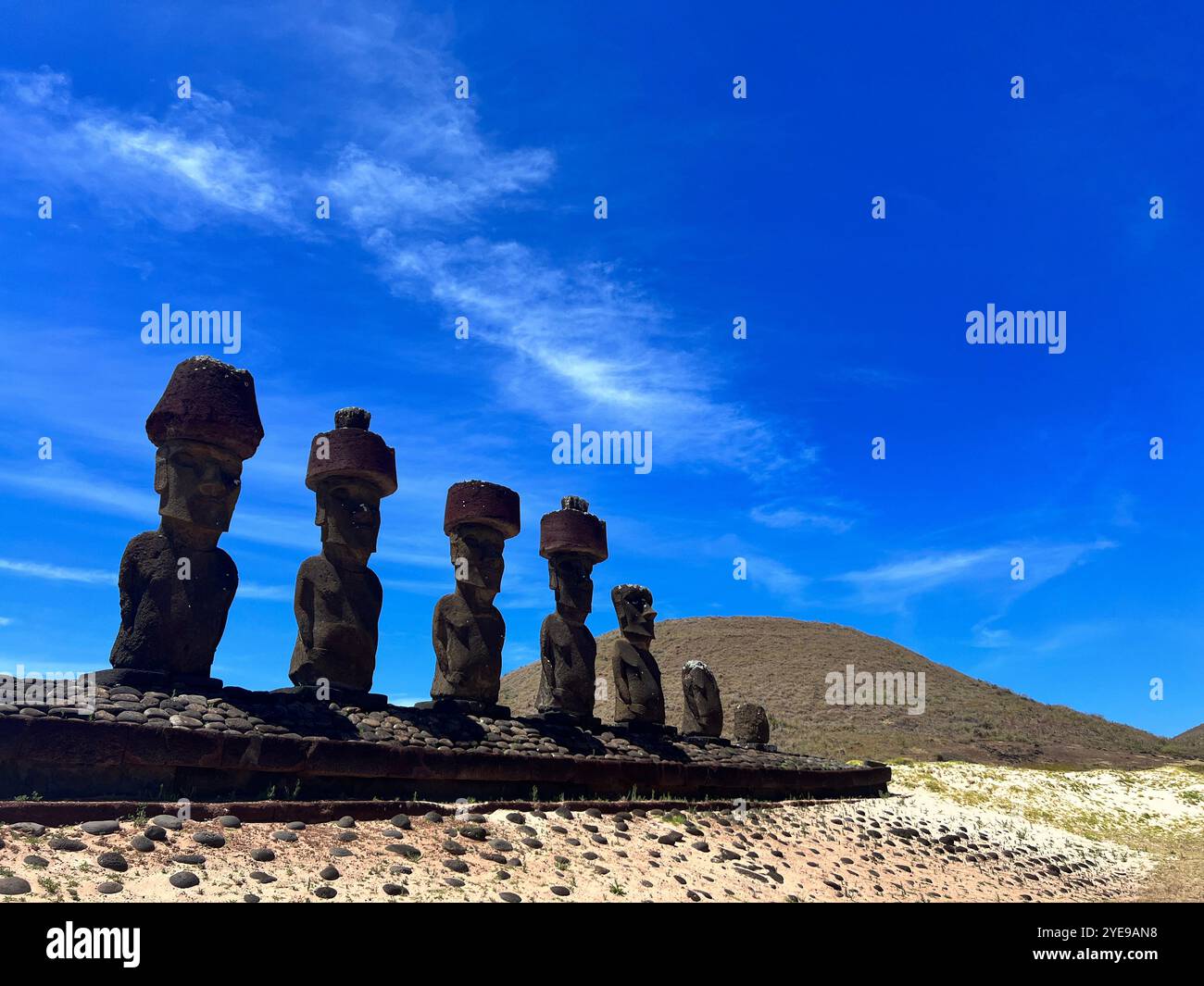 Rangée de statues moai avec coiffes pukao rouges à Ahu Tongariki île de Pâques, Chili, debout sous un ciel bleu vif, symbolisant l'héritage Rapa Nui - Image de stock capturée avec un smartphone