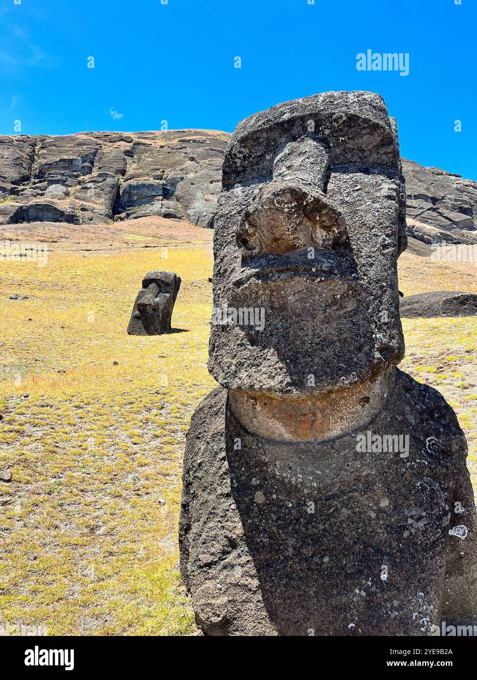 Deux statues de moai sur l'île de Pâques, au Chili, placées contre un paysage rocheux et un ciel bleu. Ces sculptures anciennes sont classées au patrimoine mondial de l'UNESCO - Image de stock capturée avec un smartphone
